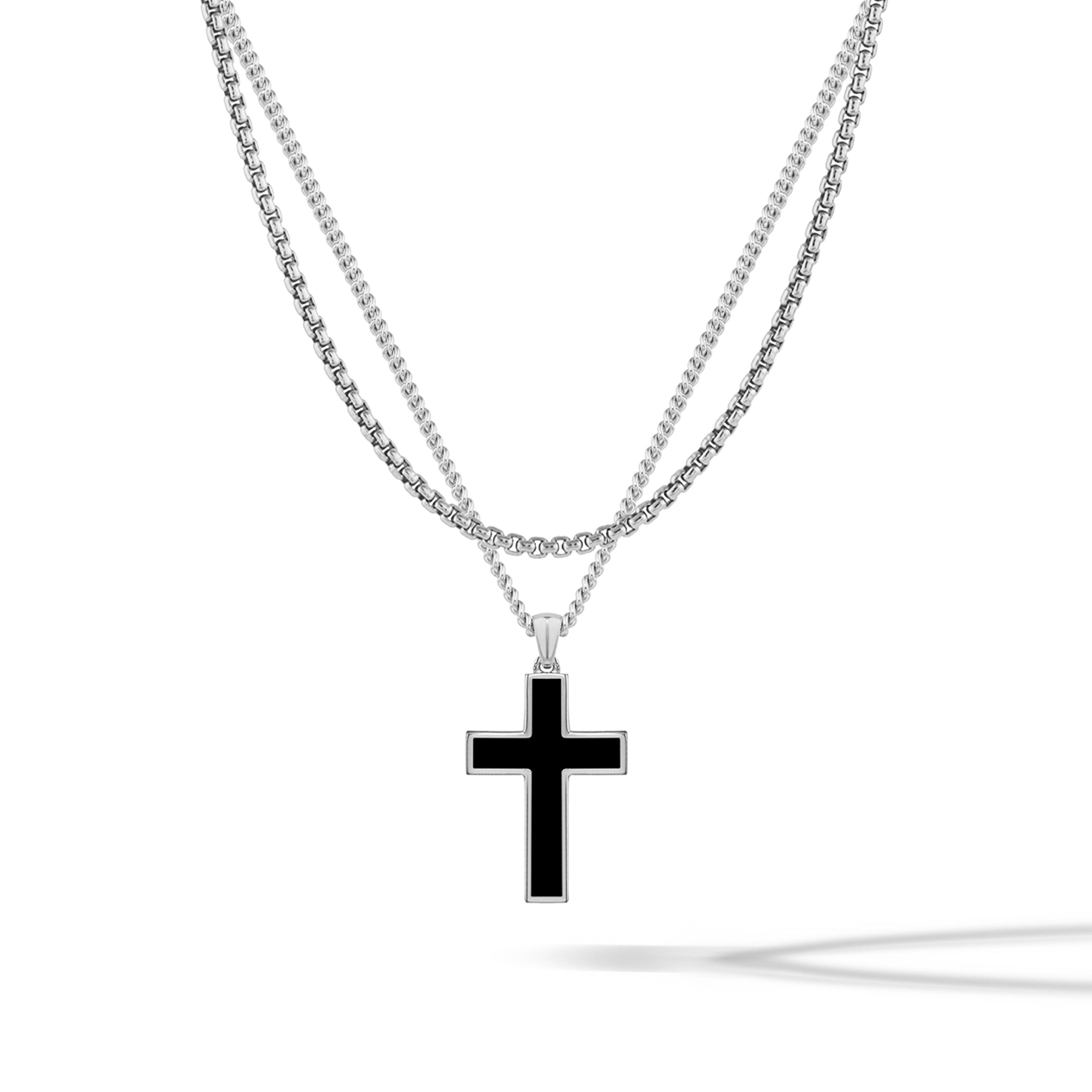 Sterling silver cross pendant hanging on a matching silver box chain.