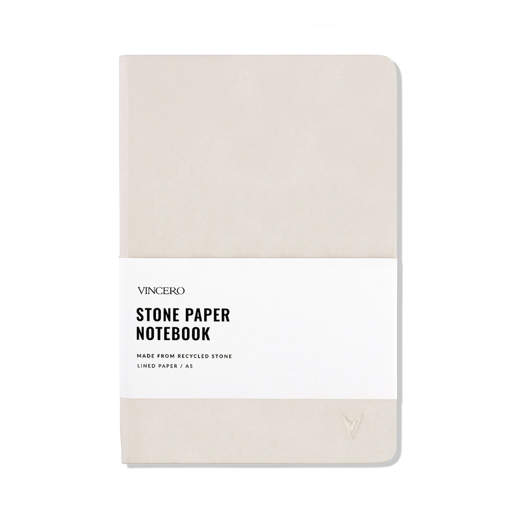 Close up of a Bone colored hardcover stone paper notebook with an elastic band and ribbon bookmark.