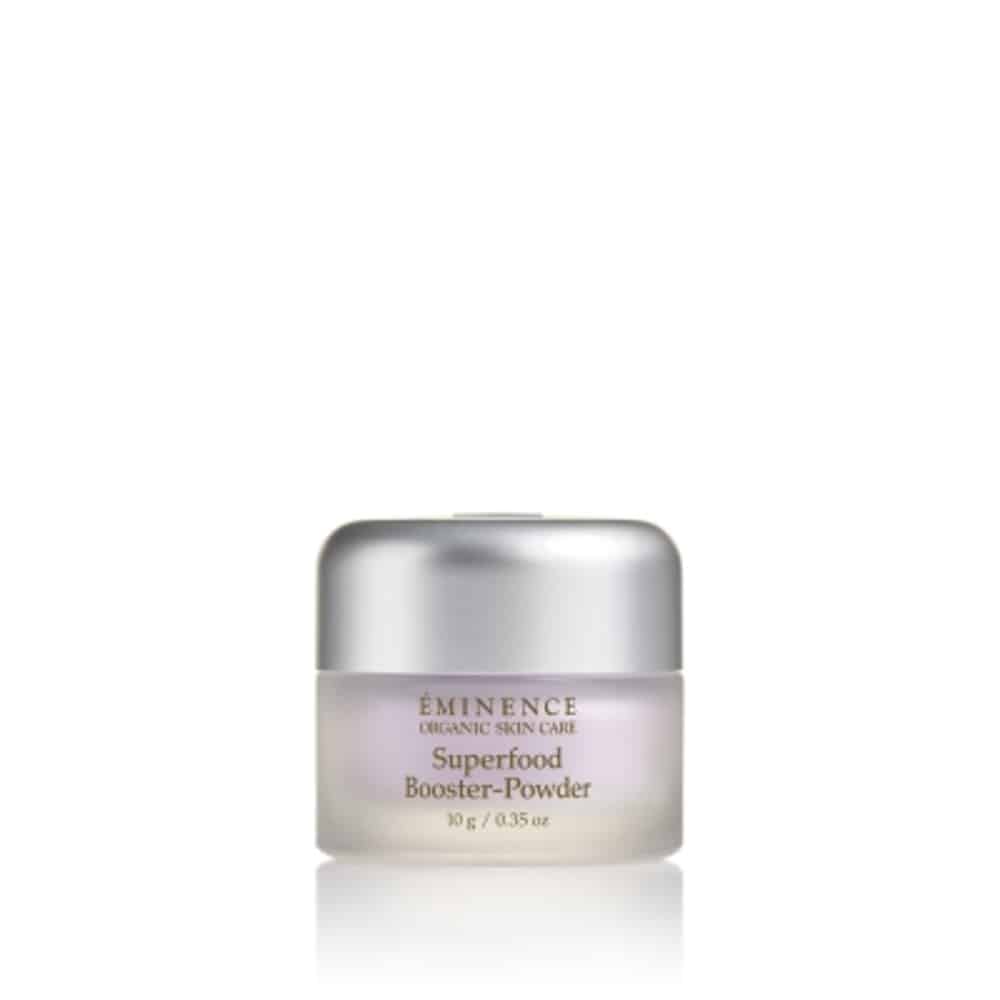 Éminence superfood booster powder in a glass container with a silver lid.