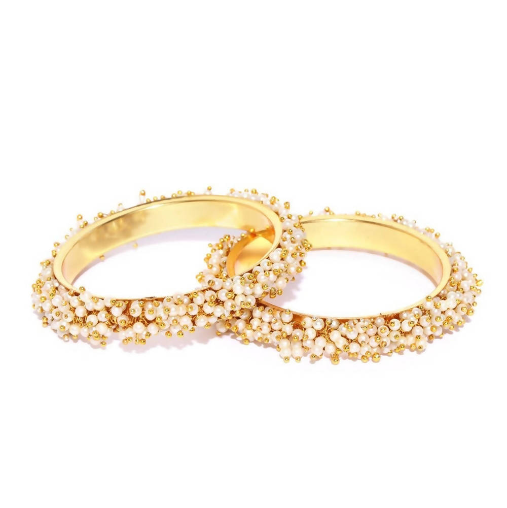 Close up view of gold-polished bangles with pearls for women