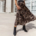 Woman wearing a leopard print pleated midi skirt with black boots