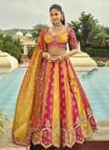 Woman wearing a yellow silk lehenga choli with heavy embroidery and art mirror work for wedding wear
