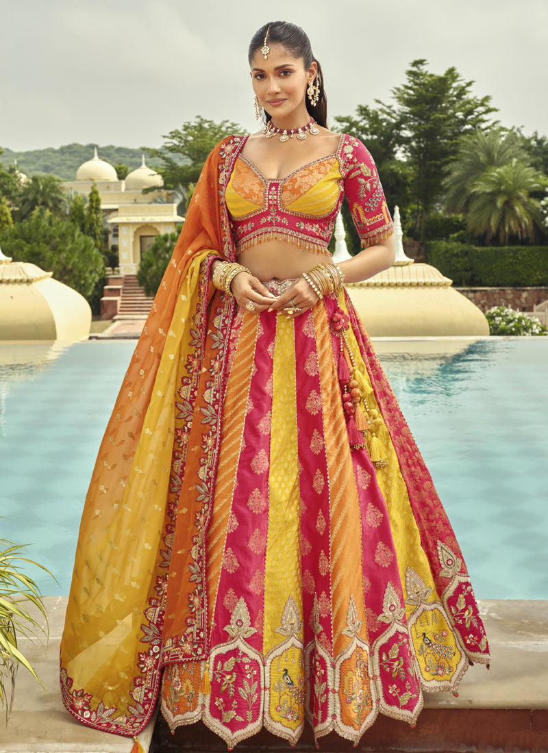Woman wearing a yellow silk lehenga choli with heavy embroidery and art mirror work for wedding wear