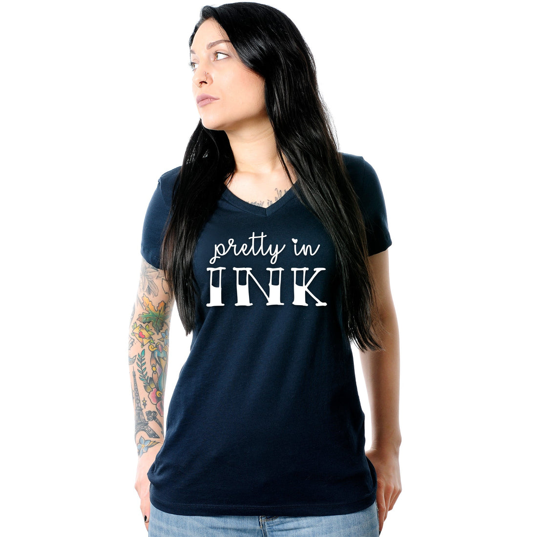 A woman wearing a navy blue v-neck t-shirt with the text Pretty in Ink printed on the front.