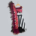 Girl wearing a printed ghagra choli with striped skirt and black, wine, and purple frilled dupatta