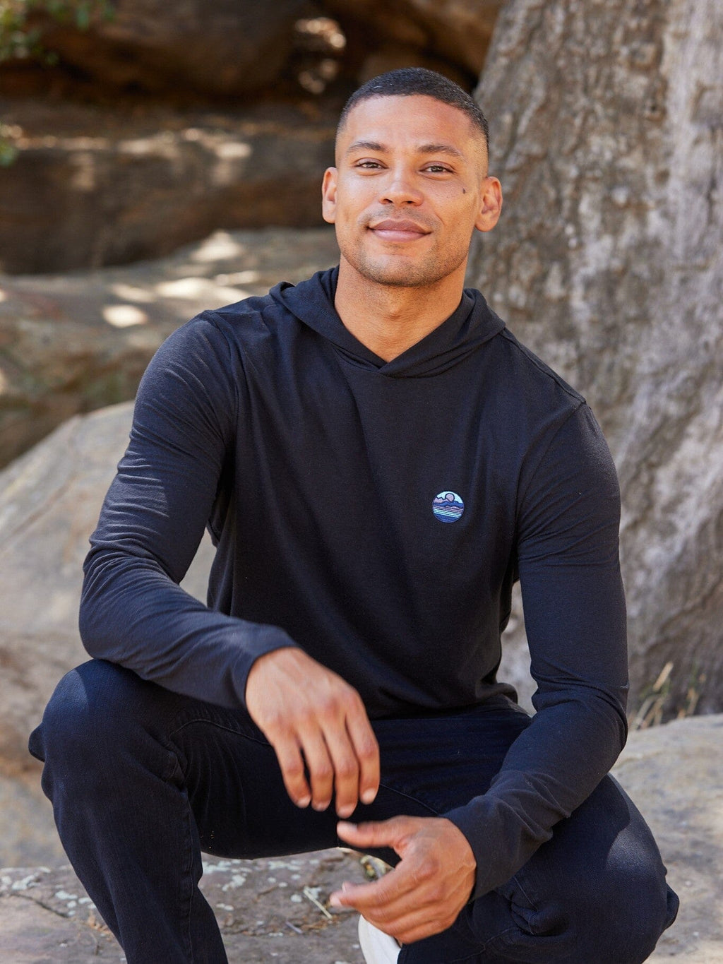 Black long-sleeve triblend hoodie tee with small embroidery detail on the chest.