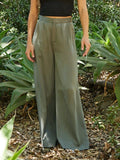 Woman wearing olive green Samirah EcoVero wide leg pleated pants with a clean waistband.