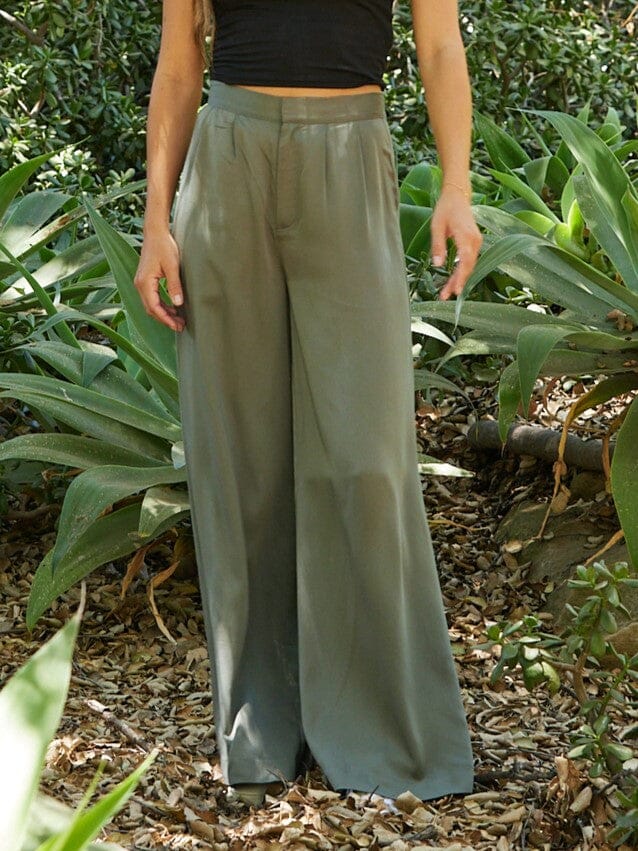 Woman wearing olive green Samirah EcoVero wide leg pleated pants with a clean waistband.