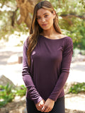 Model wearing a dark purple Leoni Feather Rib long sleeve off-shoulder top with a relaxed fit.