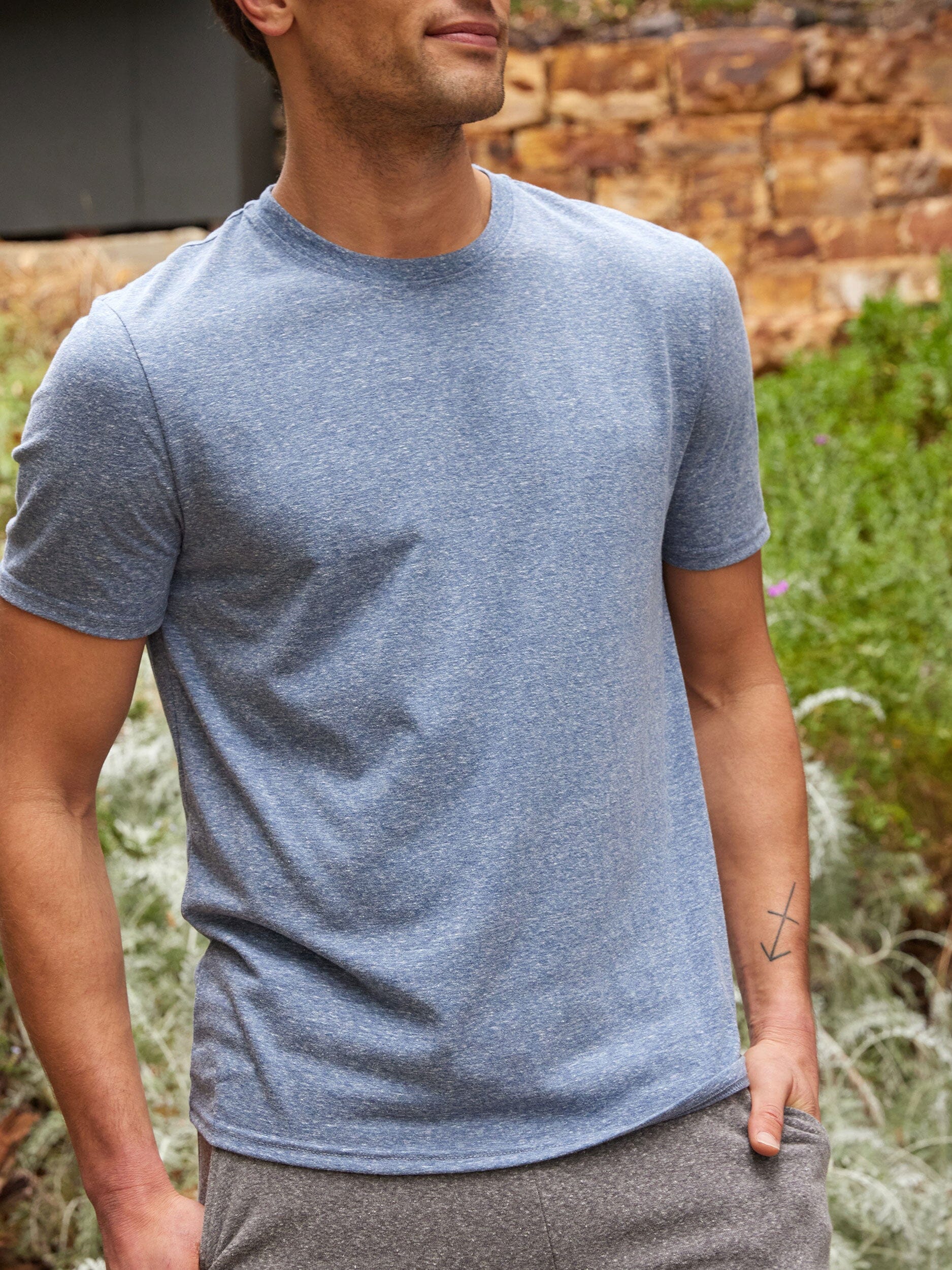 Close up of a man wearing a soft blue triblend jersey crew neck tee.