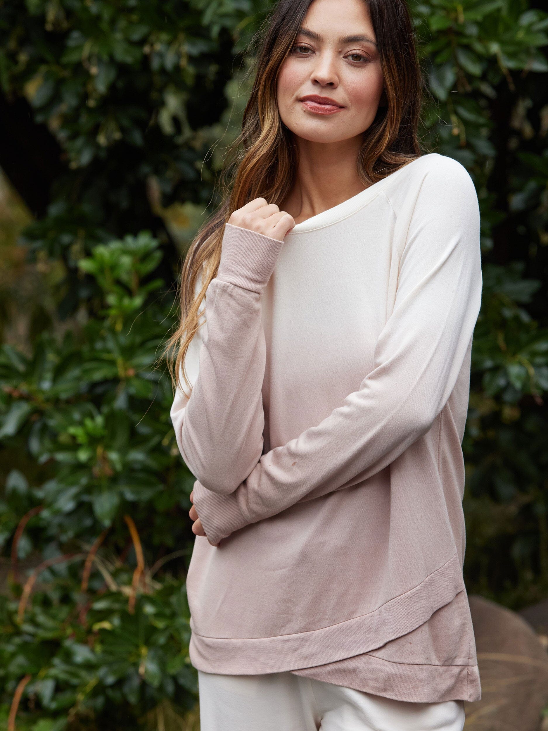 A soft blush or cream Leanna Feather Fleece Tunic featuring a tulip hem.