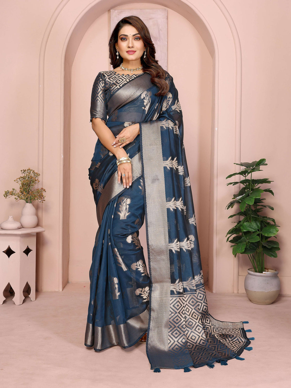 A Teal Soft Organza Silk Saree featuring intricate weaving patterns displayed on a mannequin.