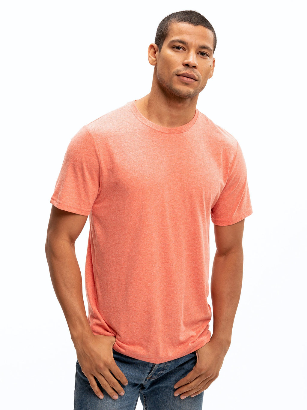 Men wearing a solid coral heathered tone crew neck triblend jersey tee in a minimalist casual setting.