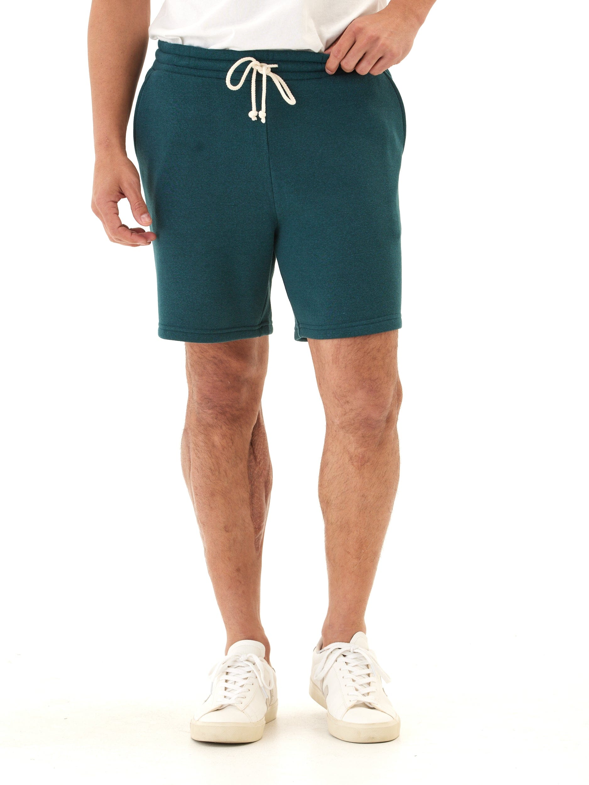 Men wearing deep teal triblend knit fleece shorts with off-white drawstring and regular fit.