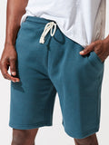 Men wearing teal Garrett 9-inch triblend knit shorts for a modern athleisure style