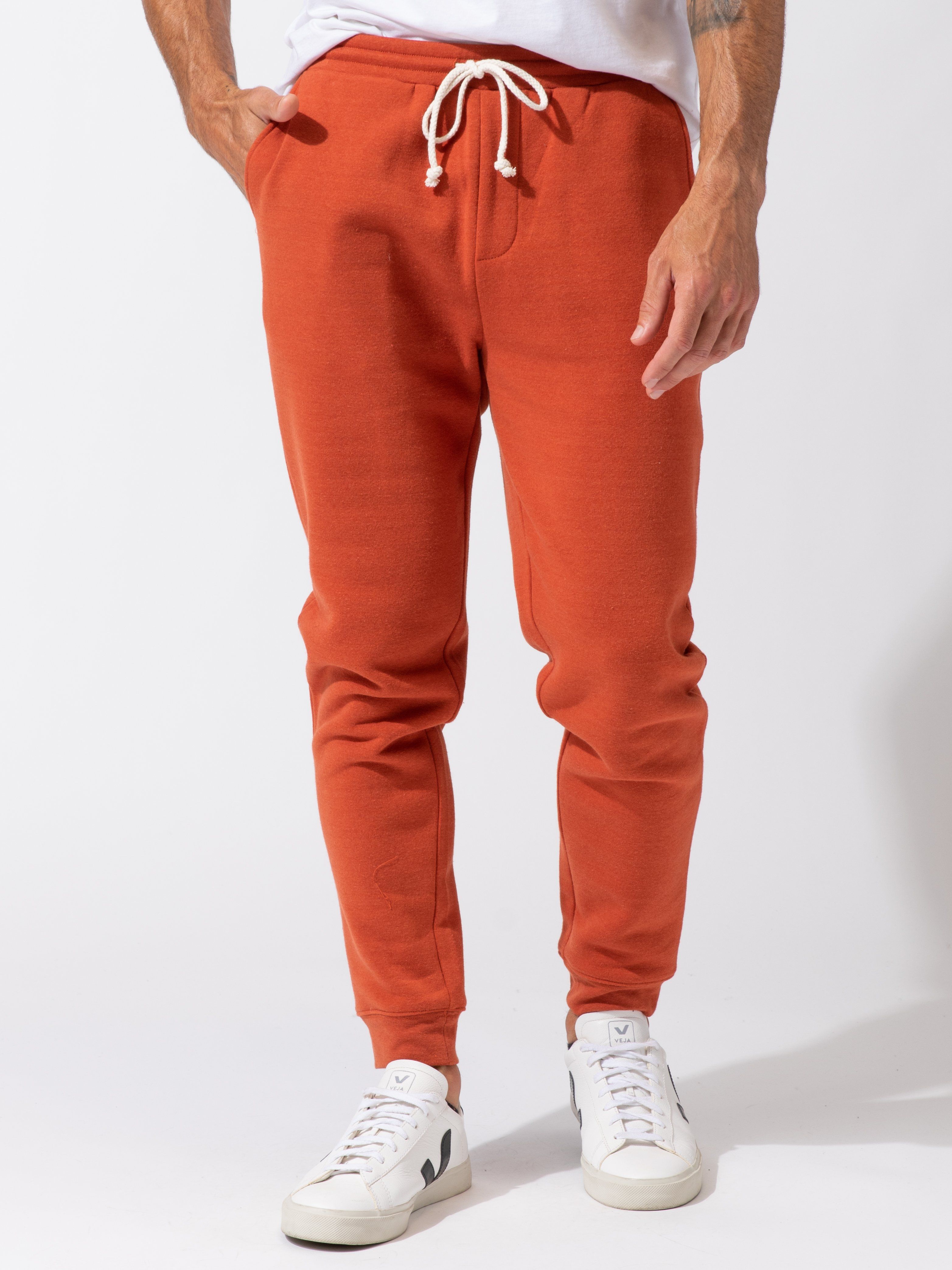 Men wearing rust-colored triblend fleece joggers in a relaxed tapered fit for a casual athleisure look.