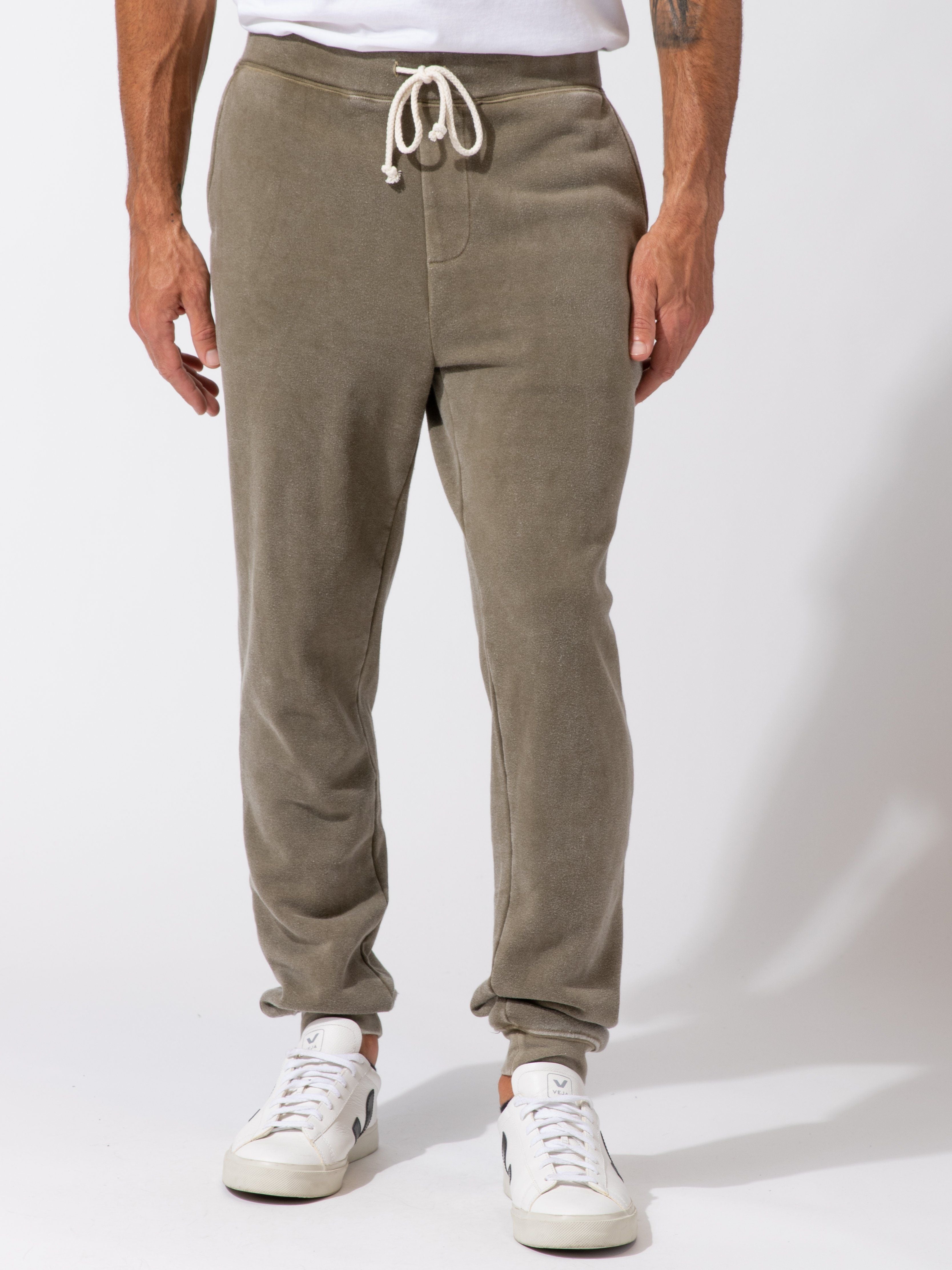 Men wearing olive green mineral wash knit fleece joggers in a casual athleisure setting