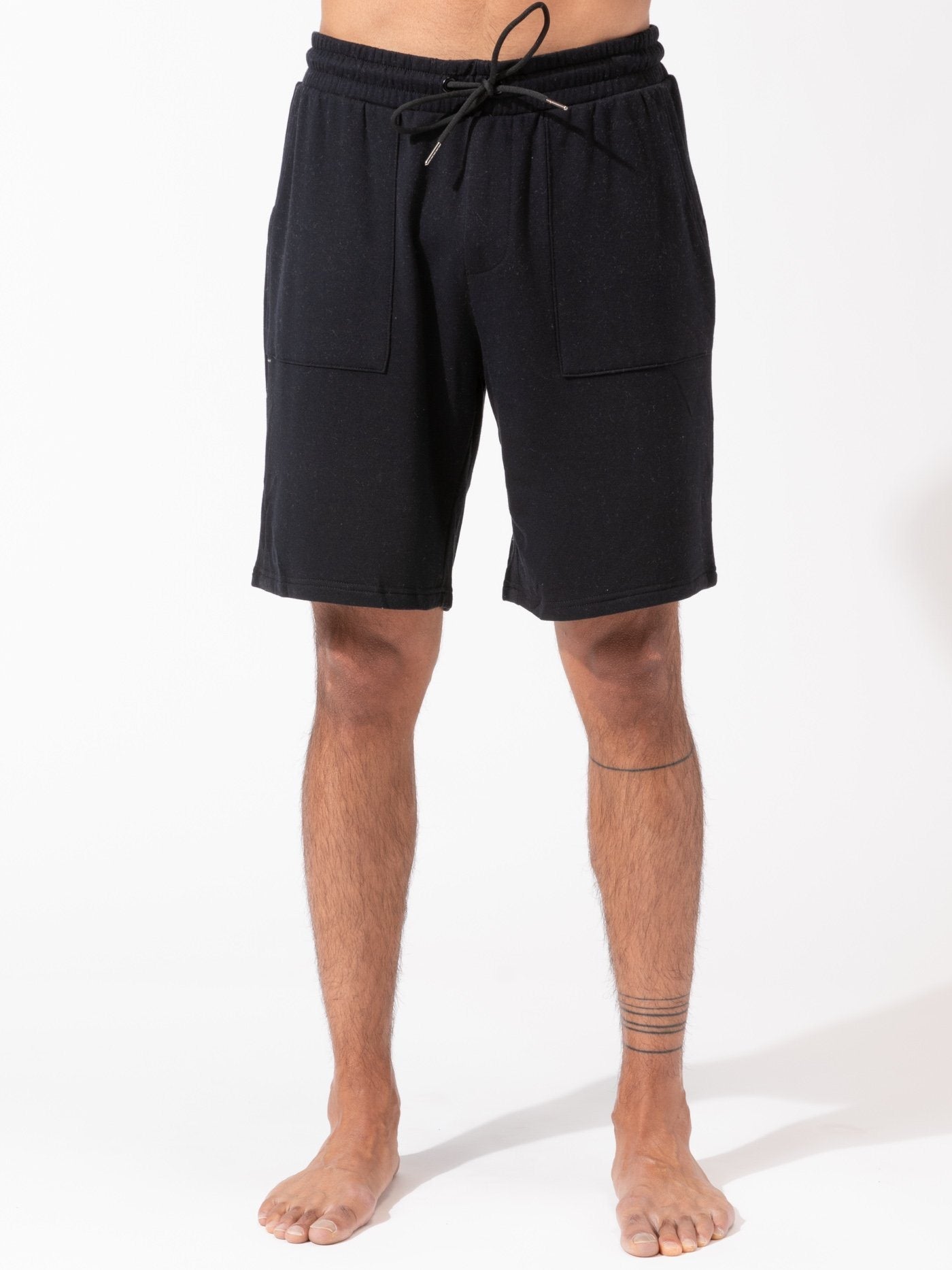 Men wearing black 9-inch relaxed fit fleece lounge shorts in a sporty, minimalist style.
