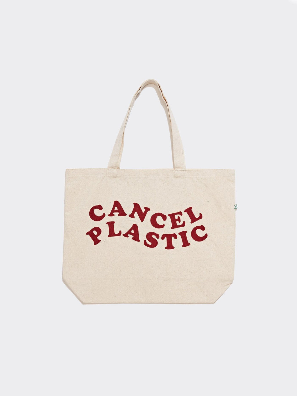 Natural beige canvas tote bag with deep red Cancel Plastic graphic text, 20x14 inches