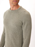 Men wearing an olive green raglan crew neck sweater in a minimalist knit fabric