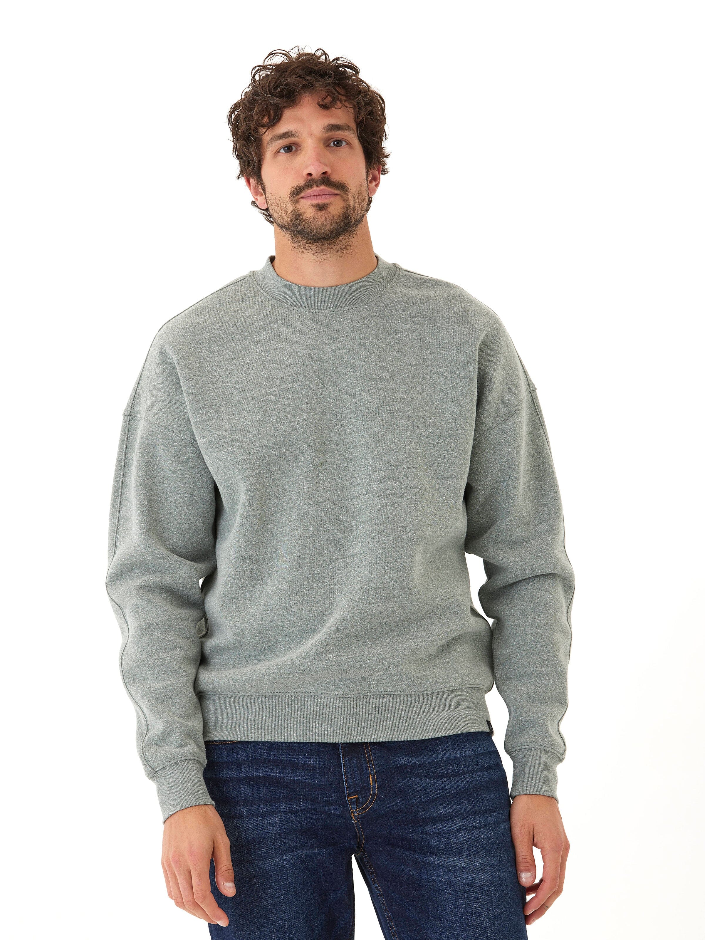 Men wearing a grey Rudy 2.0 triblend fleece sweatshirt with drop shoulders and a branded hem tab.