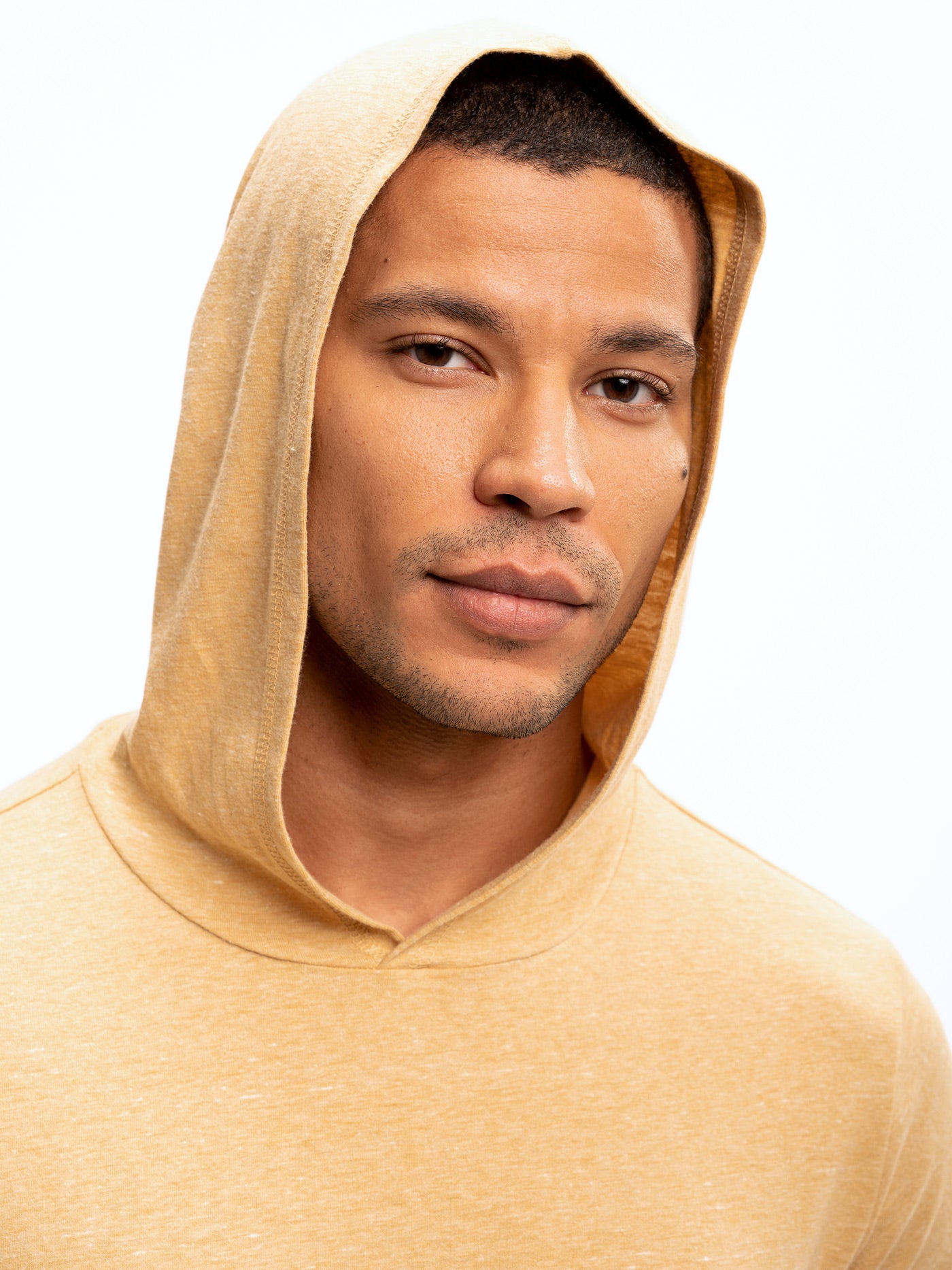 Unisex long sleeve triblend hoodie in gold yellow, featuring a casual knit tee-shirt design.