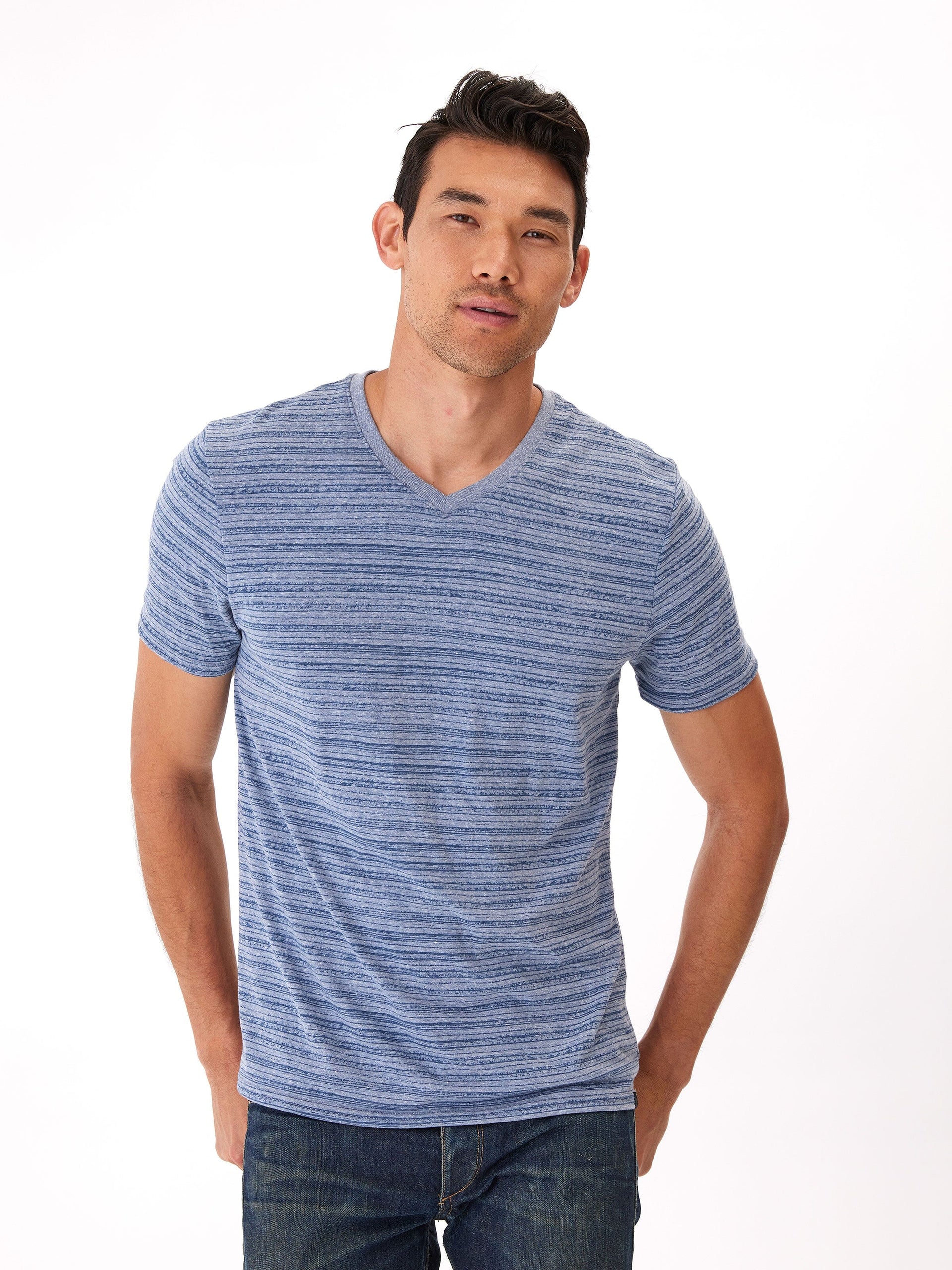 Men wearing a blue and white striped triblend jersey v-neck tee in a casual setting