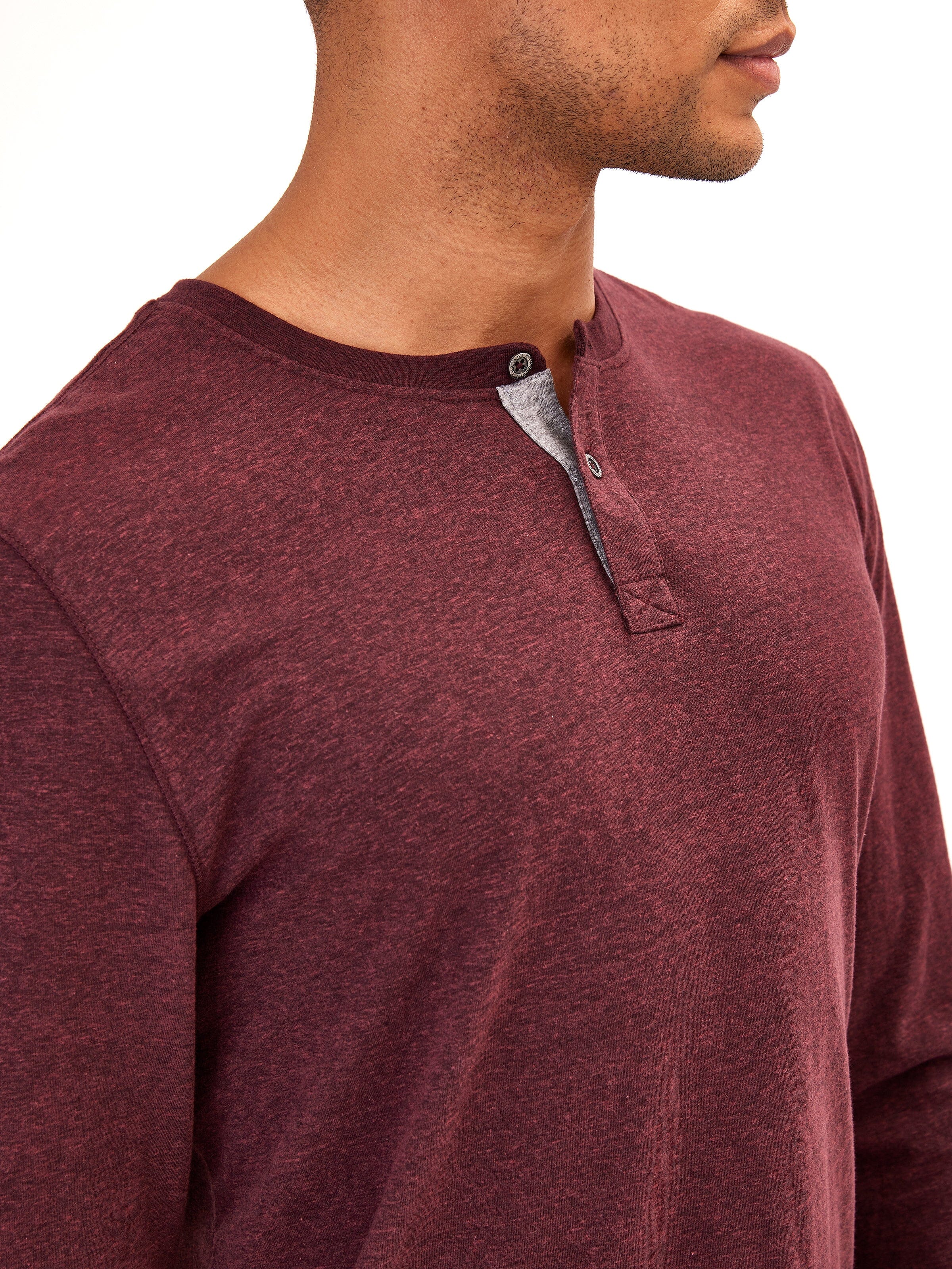 Close up of a long sleeve textured triblend henley with two-button closure and contrast neck trim.