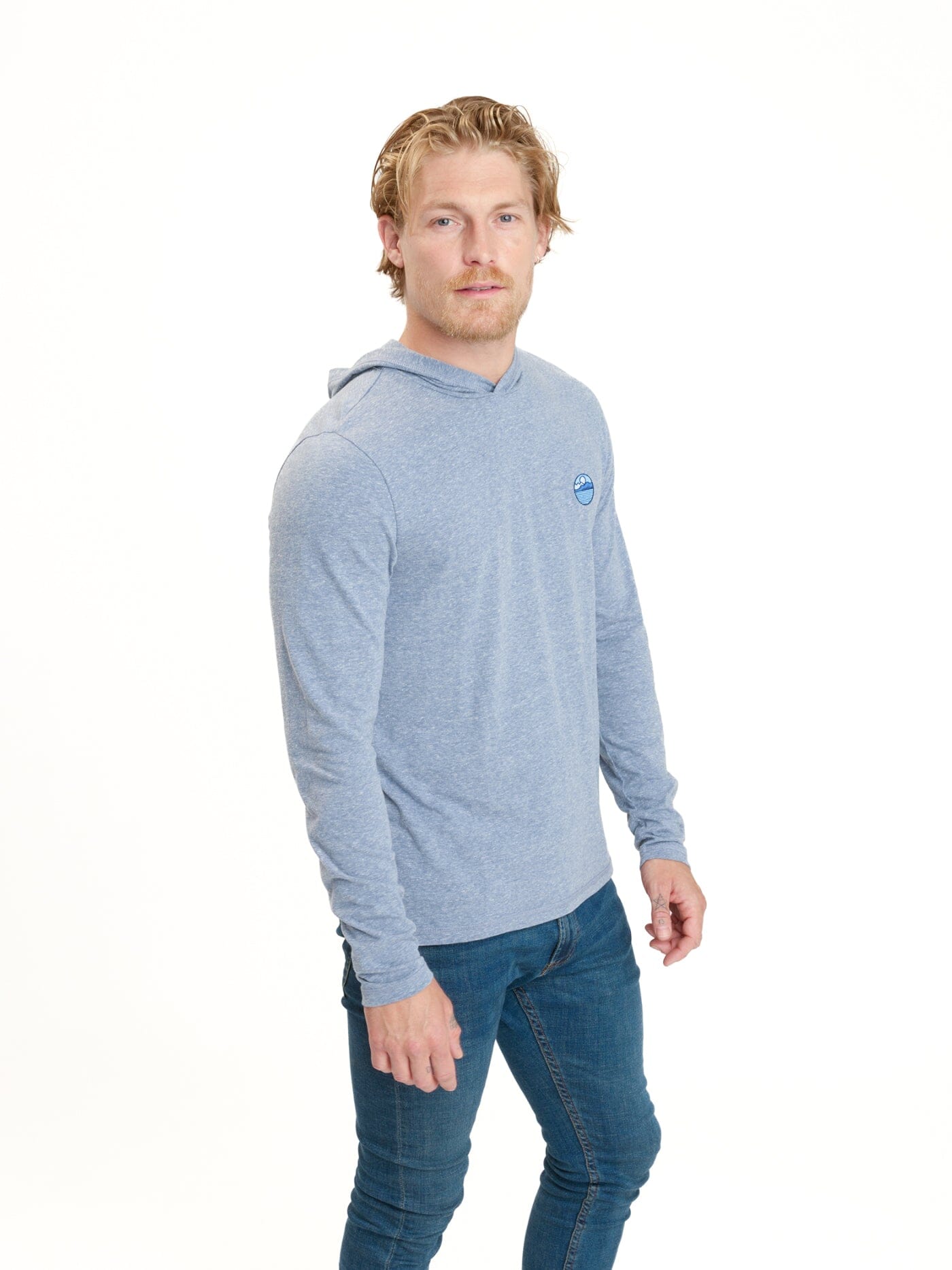 Men wearing a blue long sleeve triblend t-shirt hoodie in a casual outdoor setting