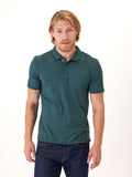 Man wearing a solid dark-teal Luxe Jersey polo shirt in a minimalist style
