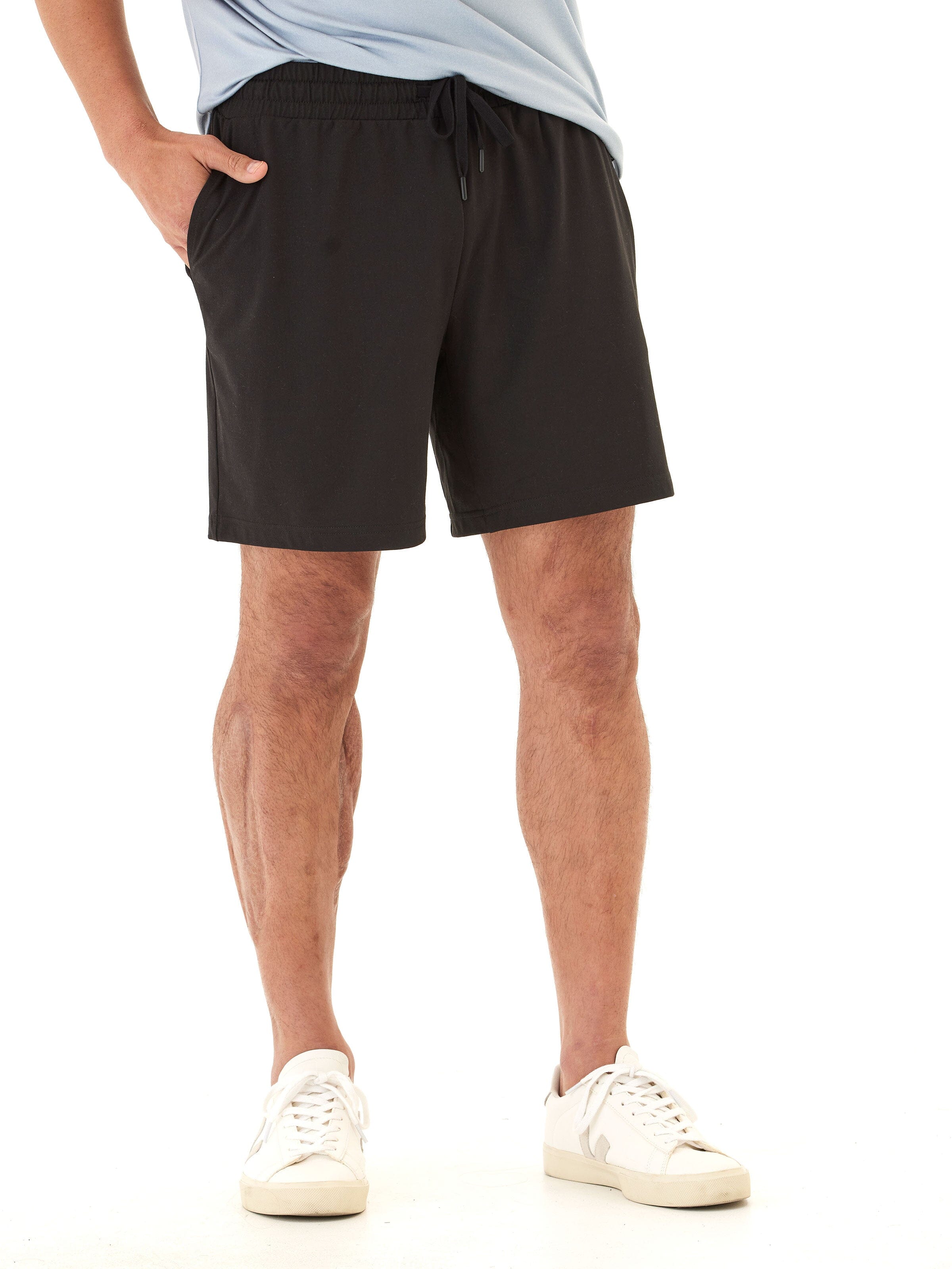 Men wearing black minimalist Luxe Jersey mid-length shorts with an elastic drawstring waist.