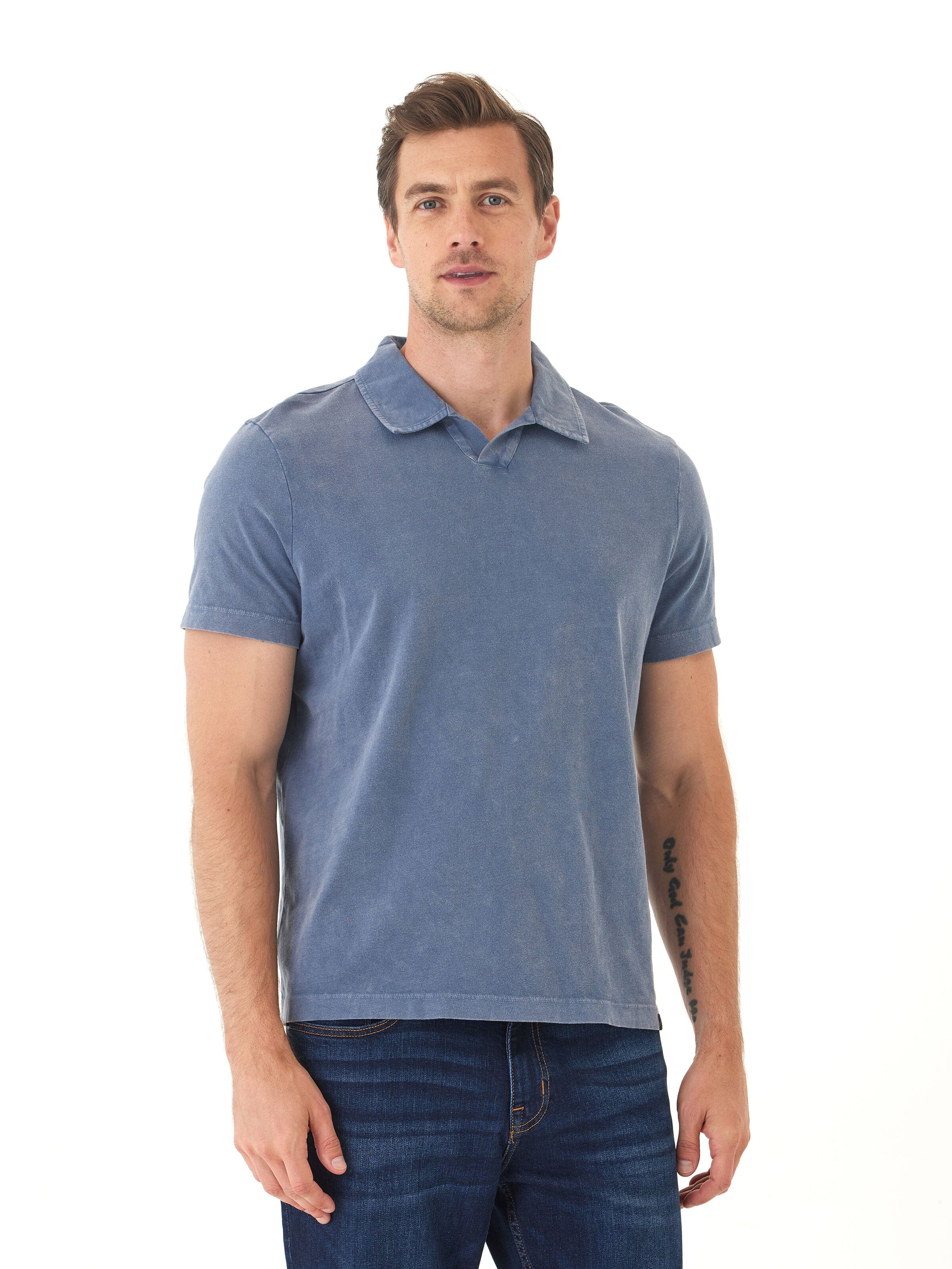 Close-up of a blue men's mineral wash polo shirt showing raw edge collar and cotton jersey texture.