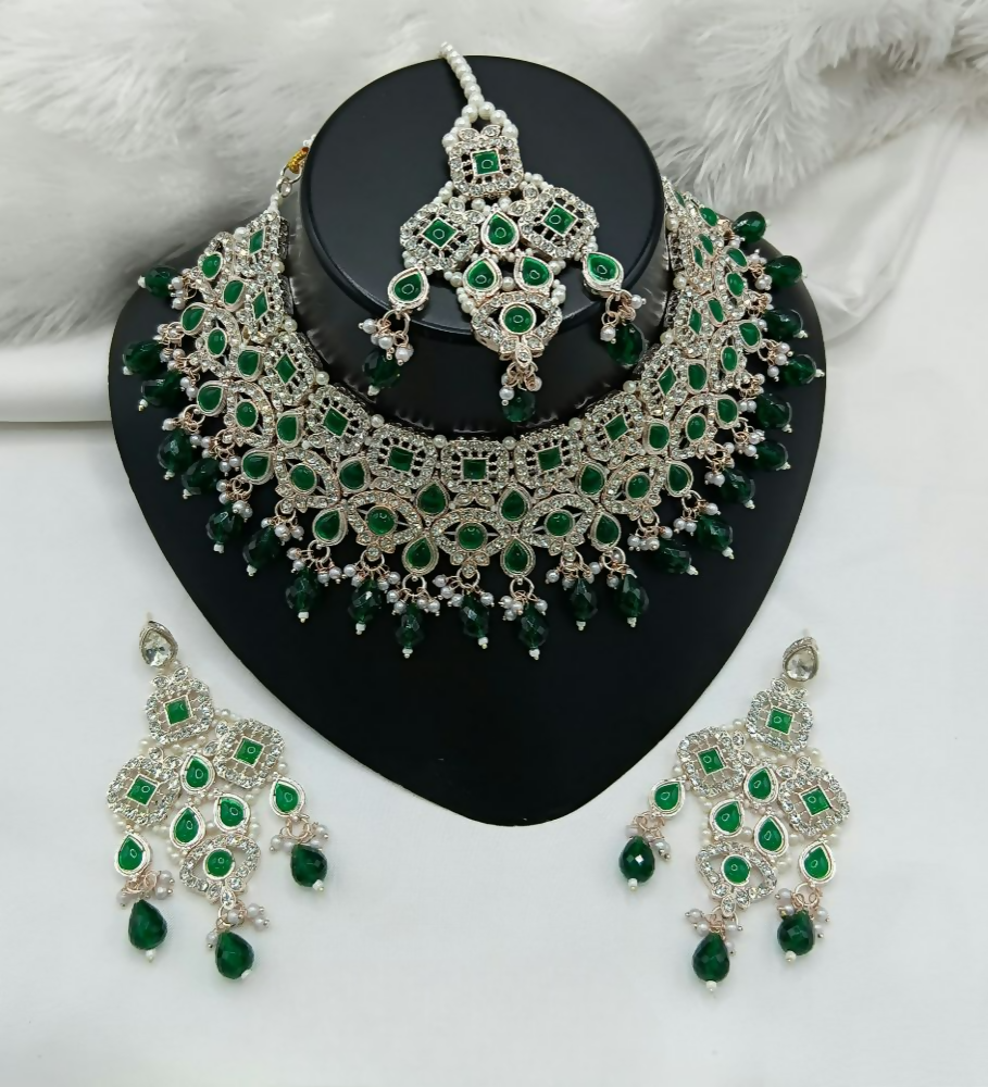 Exquisite green stone necklace set with matching earrings and maang tikka for festive wear