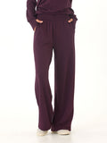 Close up of dark purple Core Feather Fleece sweatpants showing the soft knit texture and fluid drape.