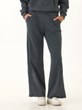 Women wearing relaxed wide-leg Core Feather Fleece sweatpants in charcoal grey with an elastic waistband.