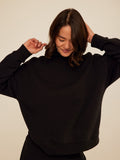 Model wearing a soft, relaxed fit triblend fleece mock neck pullover in a neutral tone