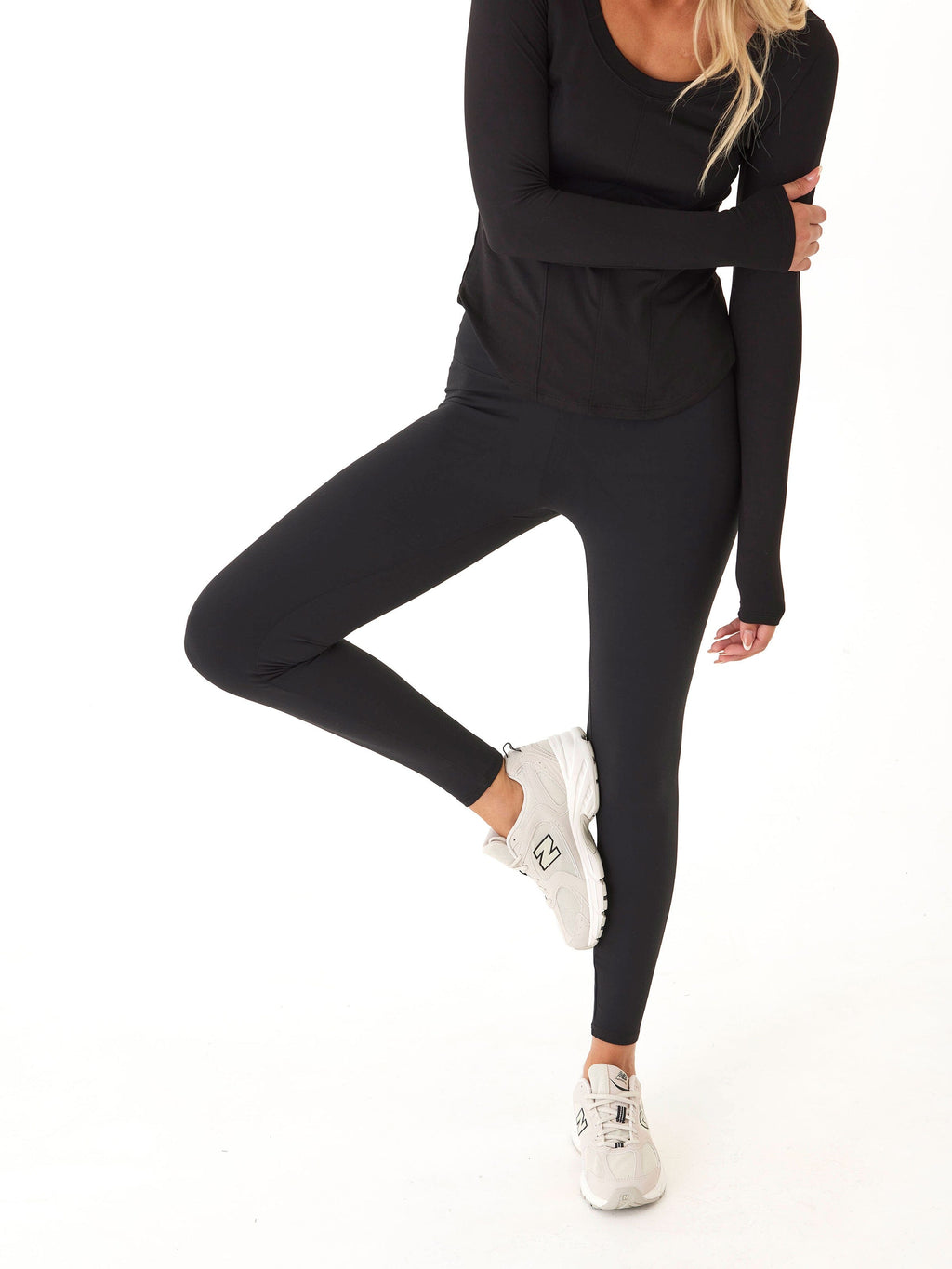 Woman wearing Monica Mid Rise Full Length Leggings in solid black, featuring a tapered fit and pull-on waistband.