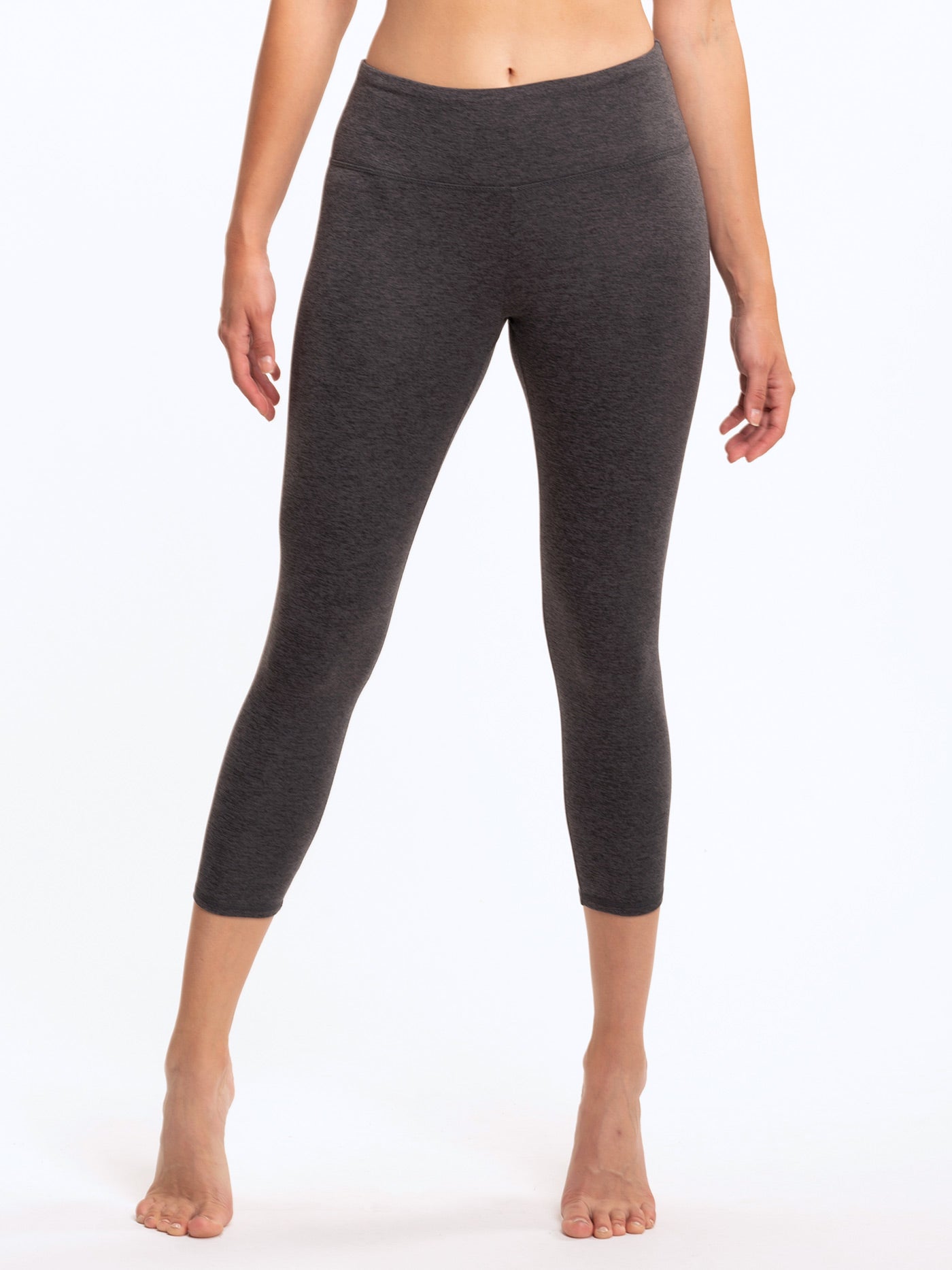 Model wearing dark heathered charcoal grey Monica 21 inch cropped leggings with a minimalist sporty design.