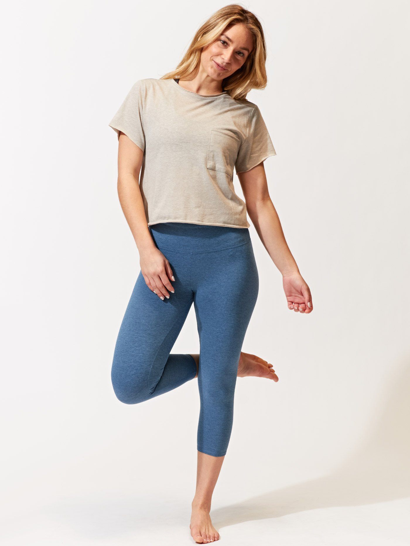 Woman wearing blue 21-inch Monica crop leggings for an active workout.