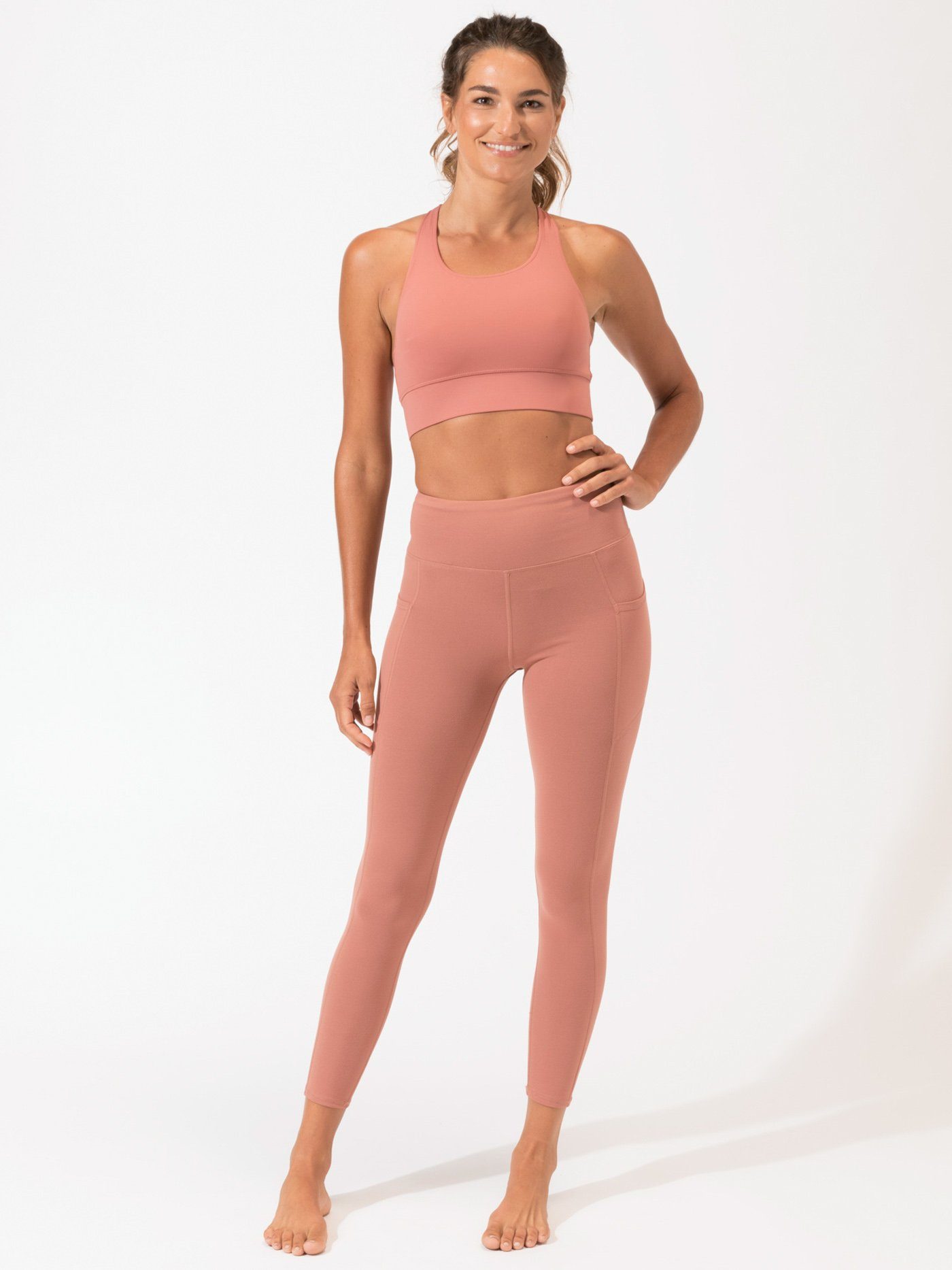 Dusty-rose ankle length leggings with side pockets and a high-rise waistband.