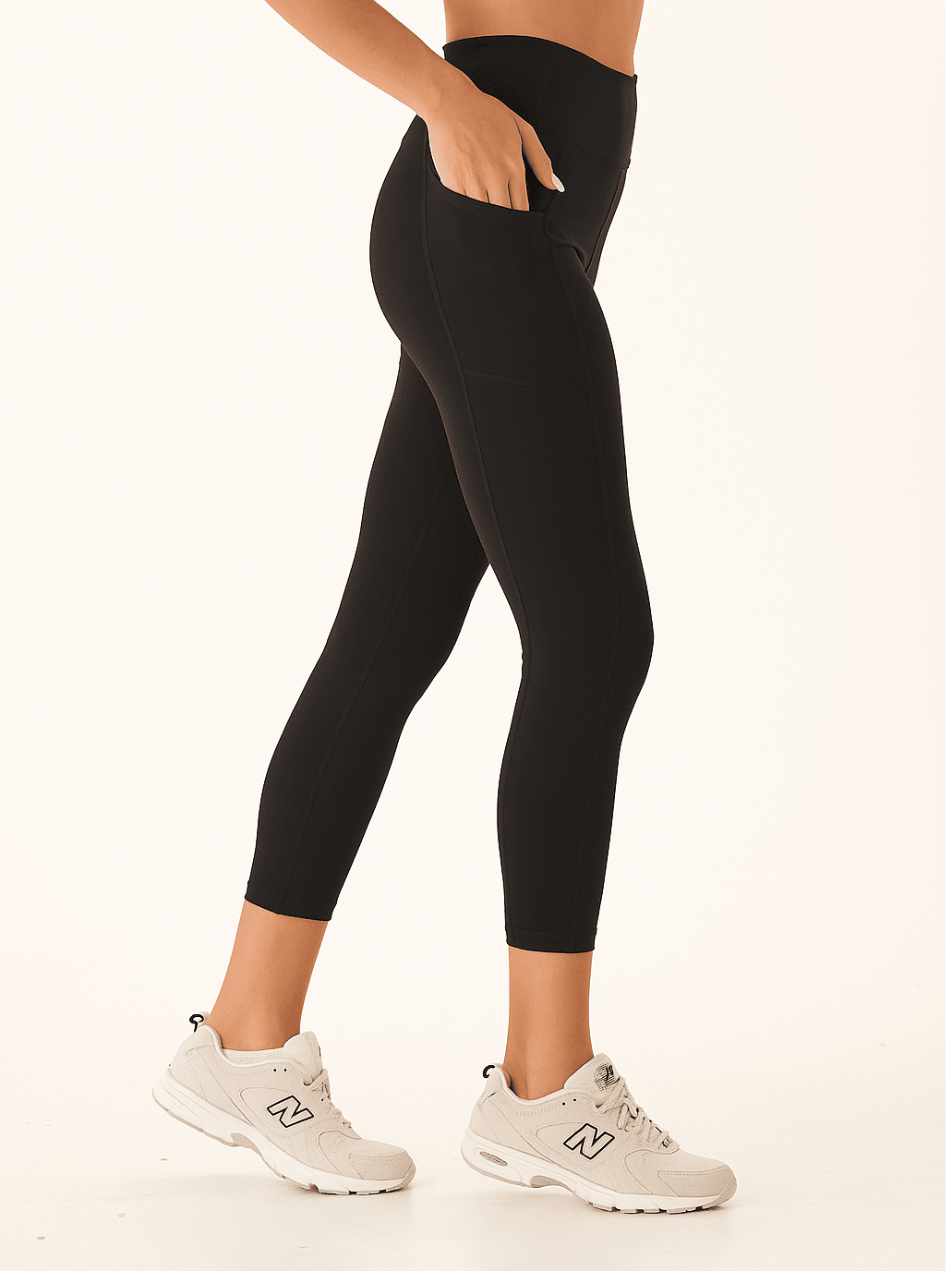 Women's black high-rise ankle-length leggings with side pockets, shown in a sporty minimalist style.