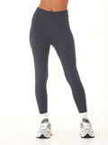 Model wearing solid charcoal grey high-rise ankle-length leggings with a sporty, fitted silhouette.