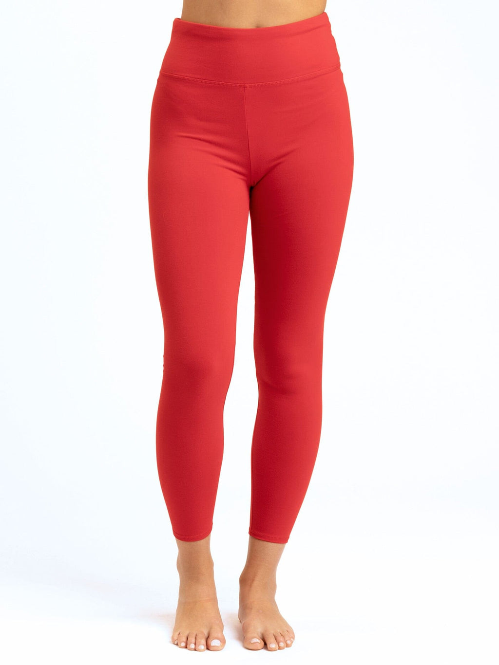 Women's minimalist vibrant red high-rise ankle length leggings with a tapered fitted silhouette.