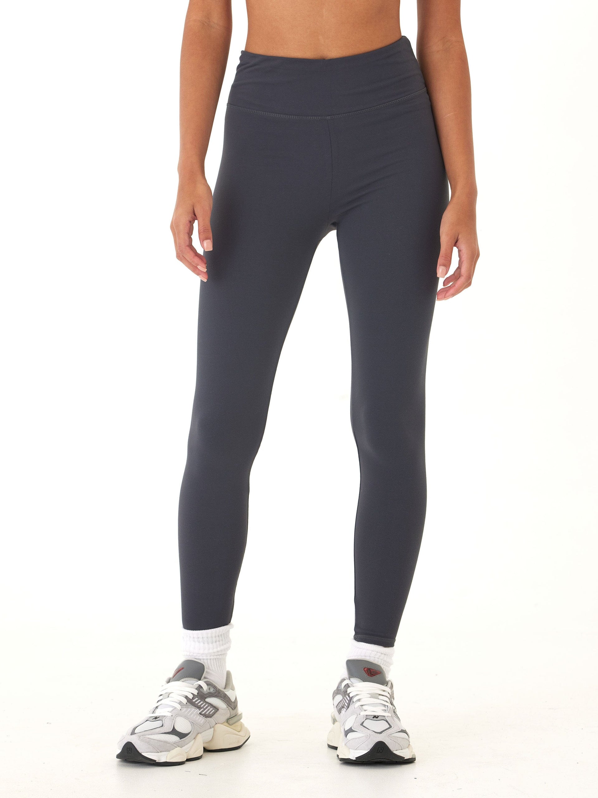 Woman wearing high-rise charcoal grey full length leggings for a sporty minimalist look