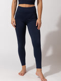 Women wearing solid navy blue full length high-rise leggings for an athletic minimalist look.