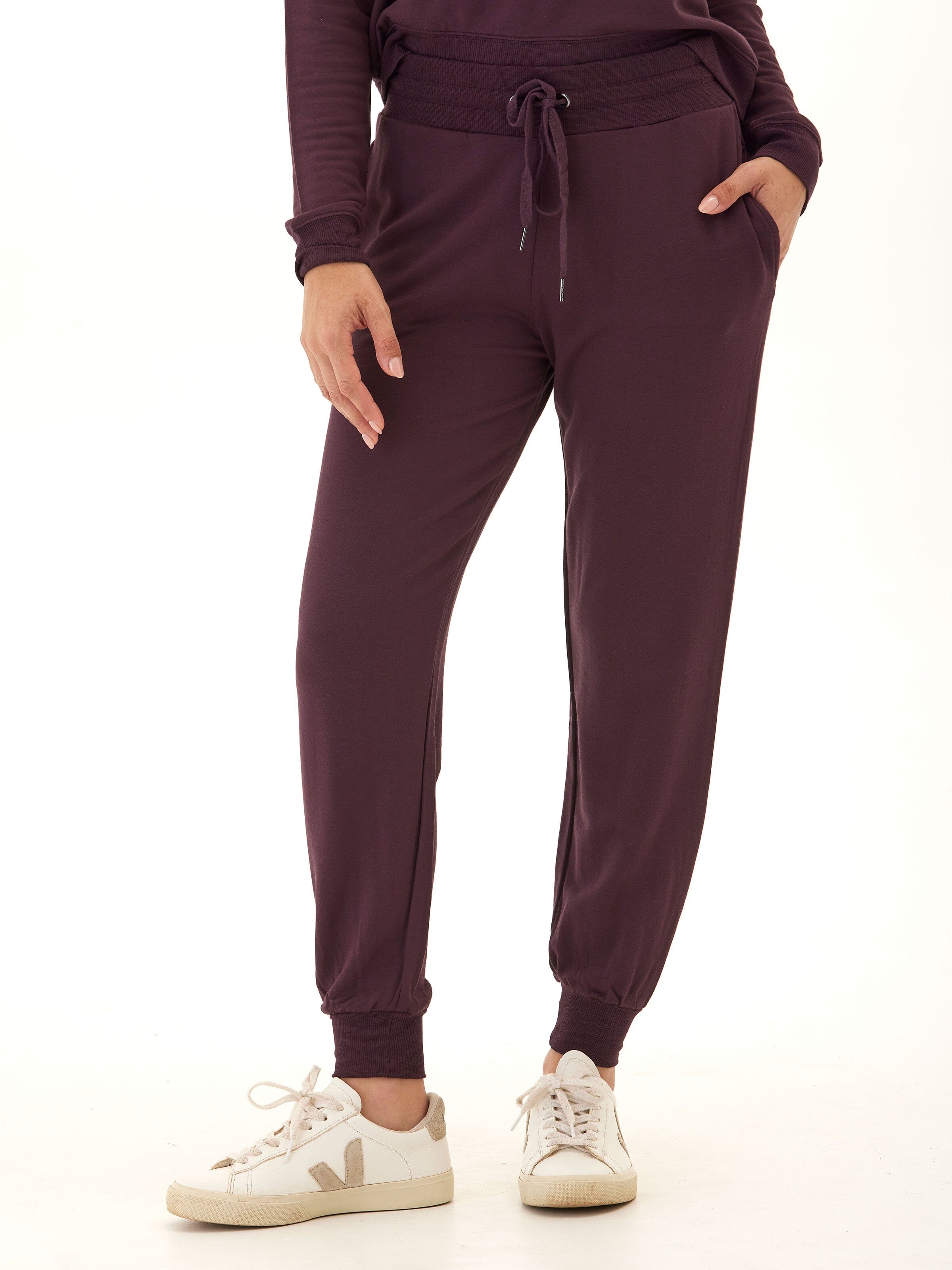 Women wearing dark purple Core Feather Fleece Joggers with a relaxed, tapered fit and pull-on waistband.