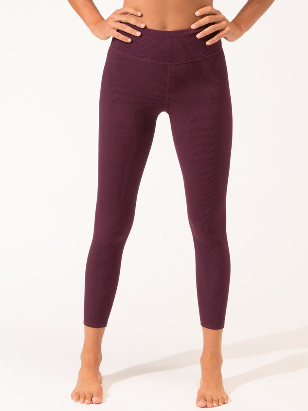 Woman wearing burgundy high-waist 7/8 rib performance jersey leggings in a sporty minimalist style.