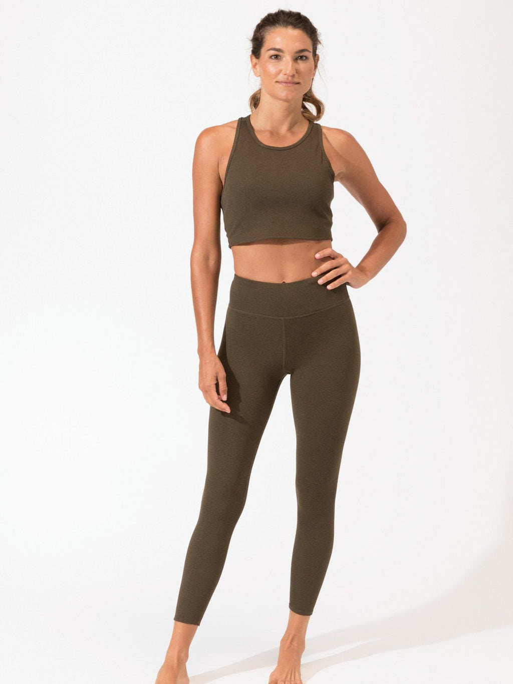 A pair of olive green high-waist ribbed leggings in a minimalist athletic style