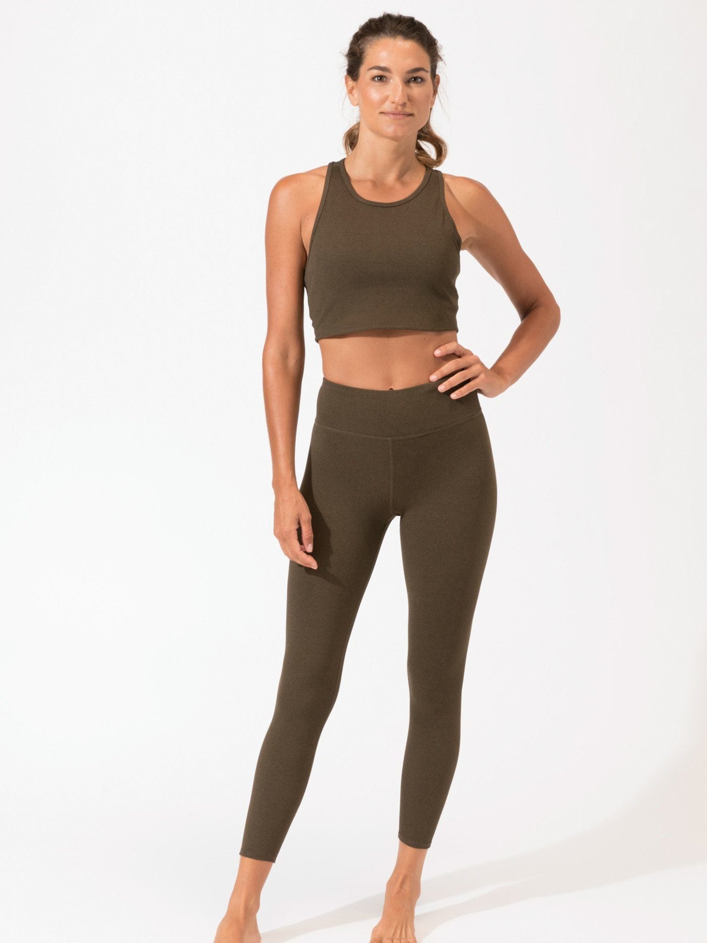 A pair of olive green high-waist ribbed leggings in a minimalist athletic style