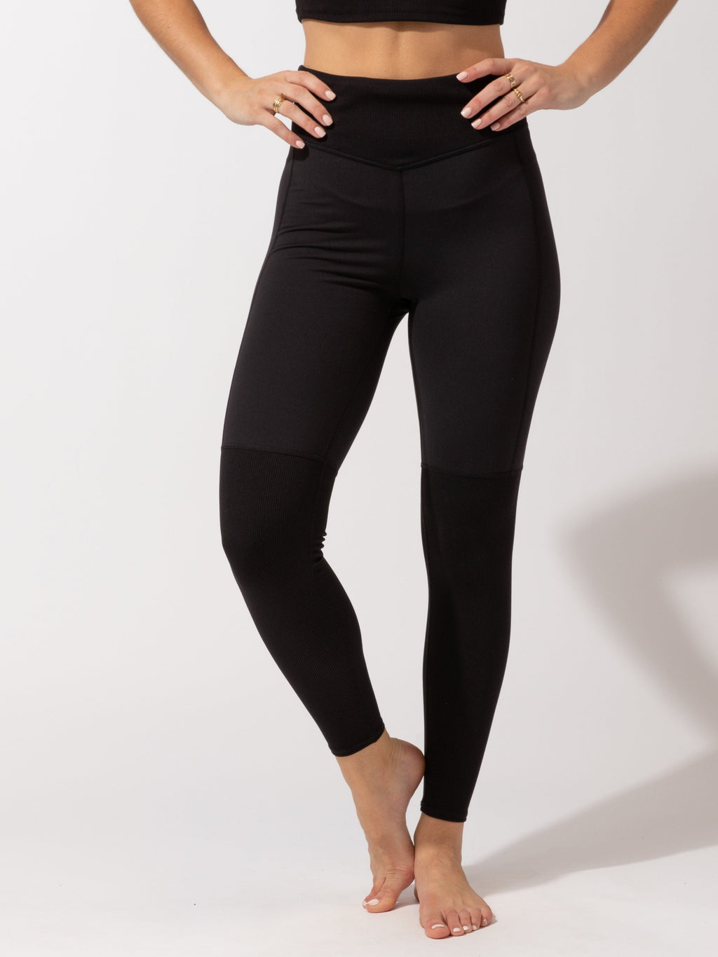 Woman wearing black Mikayla full-length leggings featuring a subtle silver waistband logo